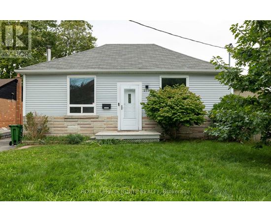 A small house with a white door and a mailbox on the front porch.
