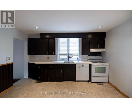 A kitchen with black cabinets and white appliances.