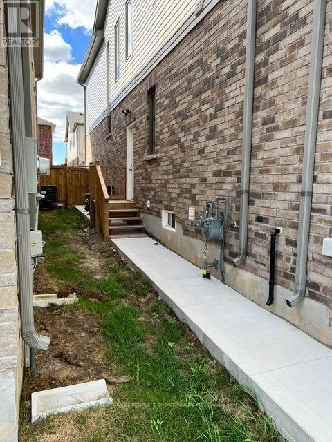 A brick building with a white wall and a concrete walkway.
