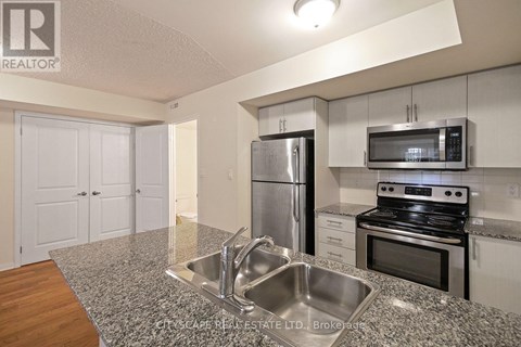 A kitchen with a stainless steel refrigerator, microwave, and oven.