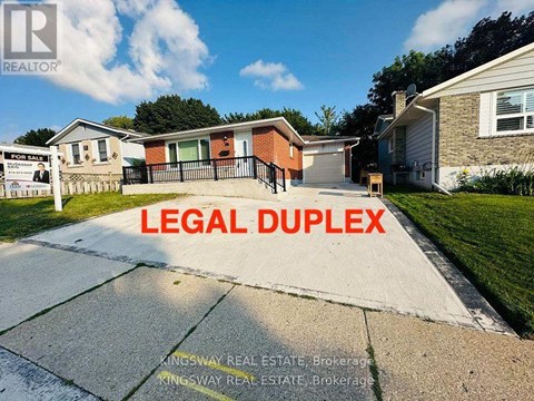 A real estate sign in front of a house with the words "LEGAL DUPLEX" written on it.