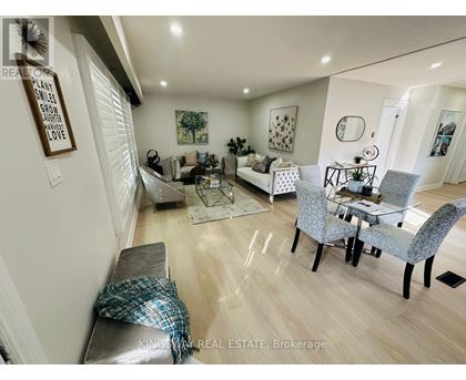A well-lit living room with a grey sofa and a glass coffee table.