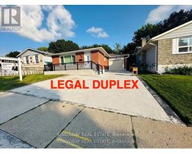 A real estate sign in front of a house with the words "LEGAL DUPLEX" written on it.