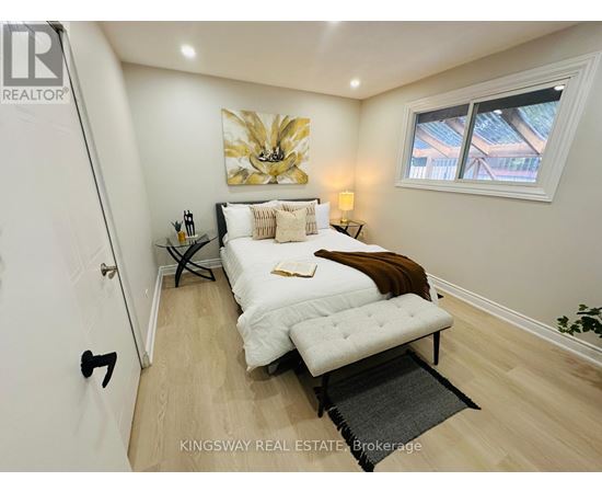 A bedroom with a bed, a bench, and a painting on the wall.