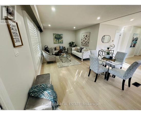A well-lit living room with a grey sofa and a glass coffee table.