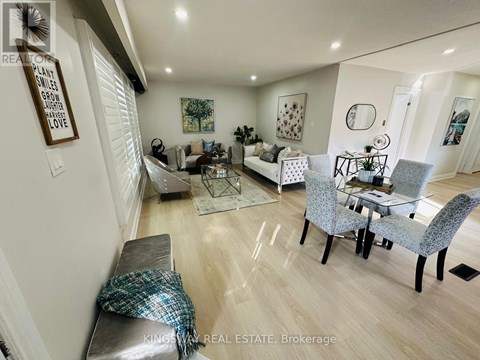 A well-lit living room with a grey sofa and a glass coffee table.