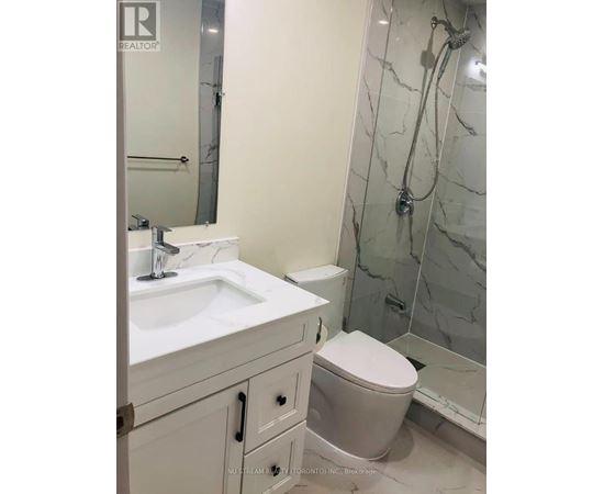 A white sink and toilet in a bathroom.