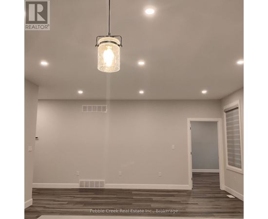 A white bathroom with a glass shower door and a toilet.