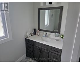 A bathroom with a sink, mirror, and a window.