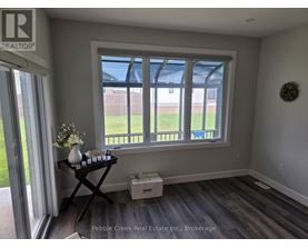 A room with a window and a table with a vase of flowers on it.
