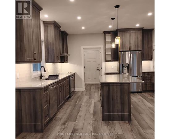 A modern kitchen with dark wood cabinets and a white countertop.