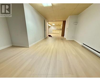 A long hallway with wooden floors and white walls.