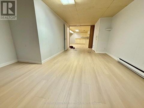 A long hallway with wooden floors and white walls.