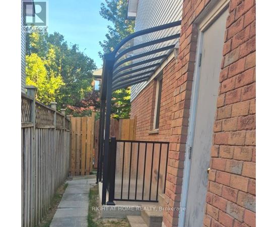 A black metal gate is on a brick wall.