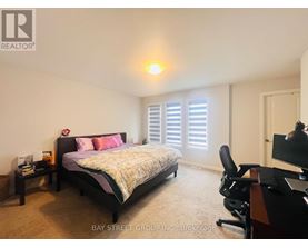A bedroom with a bed, desk, and chair.