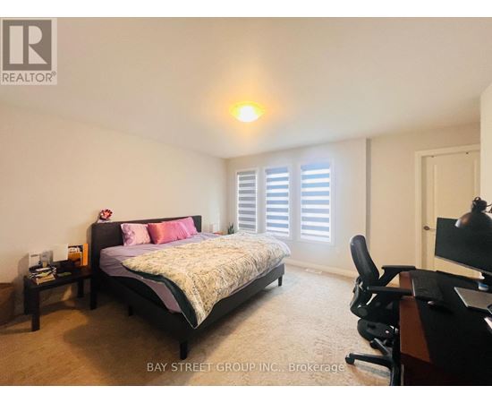 A bedroom with a bed, desk, and chair.
