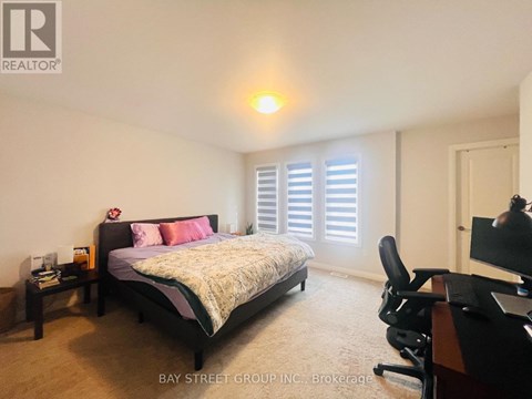 A bedroom with a bed, desk, and chair.