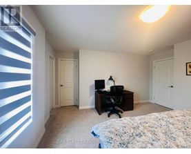 A bedroom with a bed, desk, and chair.