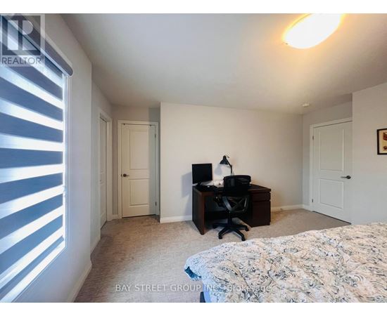 A bedroom with a bed, desk, and chair.