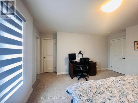 A bedroom with a bed, desk, and chair.
