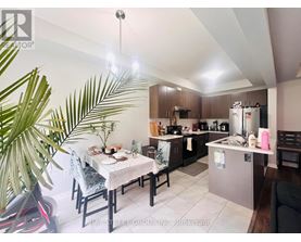 A well-lit kitchen with a dining table set for two.