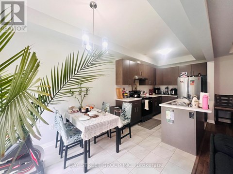 A well-lit kitchen with a dining table set for two.