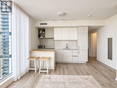A modern kitchen with white cabinets and a wooden island.