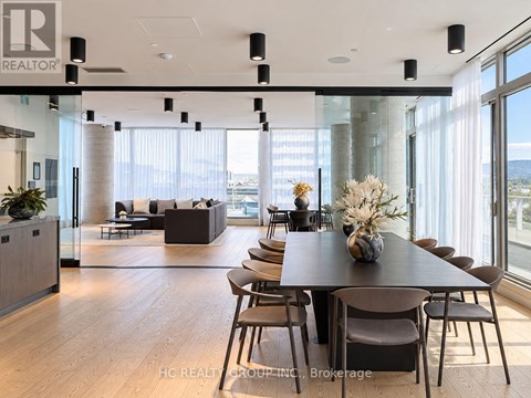 A modern dining room with a long table and chairs.