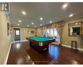 A room with a pool table and a mirror on the wall.