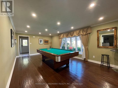 A room with a pool table and a mirror on the wall.