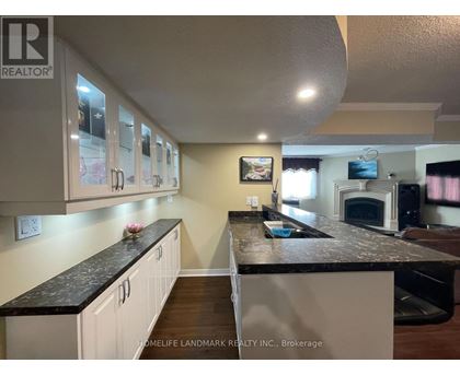 A kitchen with white cabinets and a black countertop.