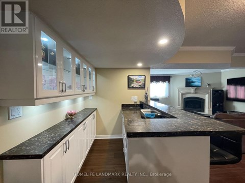 A kitchen with white cabinets and a black countertop.