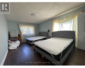 A bedroom with two beds and a window with curtains.