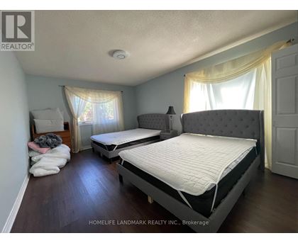 A bedroom with two beds and a window with curtains.