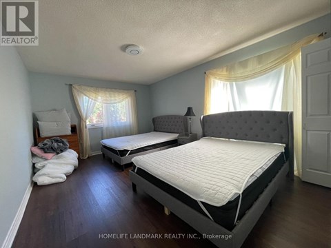 A bedroom with two beds and a window with curtains.