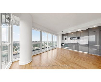 A spacious kitchen with wooden floors and stainless steel appliances.