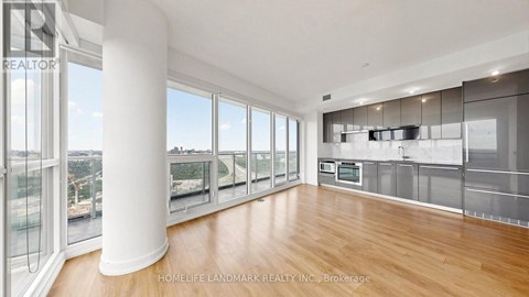 A spacious kitchen with wooden floors and stainless steel appliances.