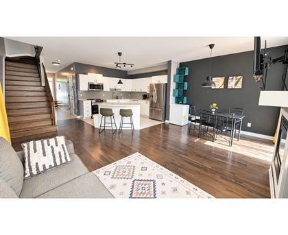 A modern living room with a grey sofa and a patterned rug.