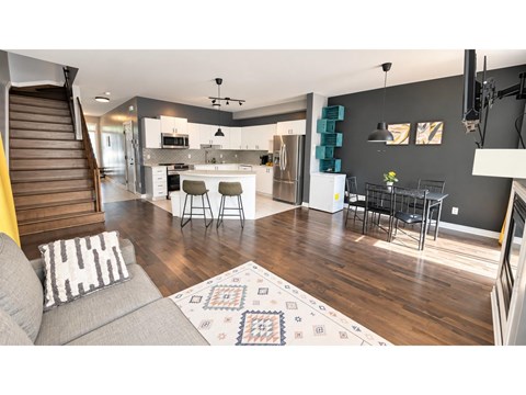 A modern living room with a grey sofa and a patterned rug.