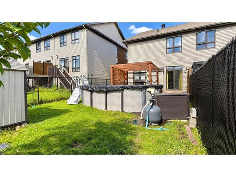 A backyard with a pool and a fence.