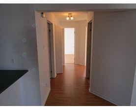 A long hallway with doors on both sides and a light at the end.