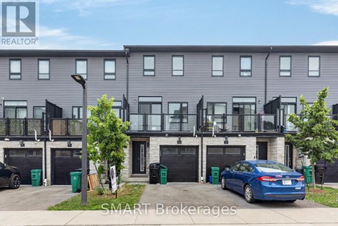 A modern two-story apartment building with balconies and a car parked in front.