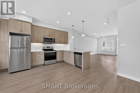 A modern kitchen with wooden cabinets and stainless steel appliances.