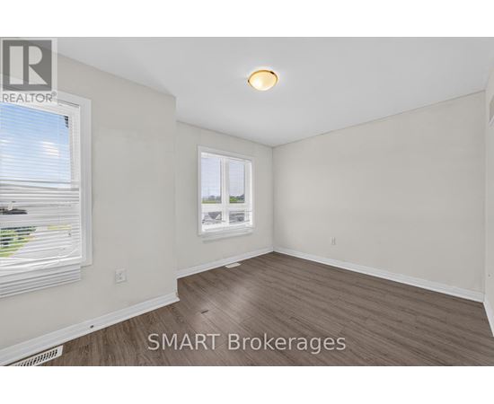 A room with a window and a wooden floor.