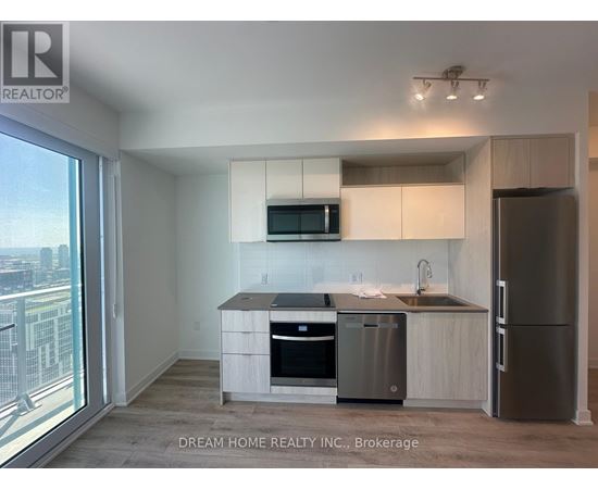 A modern kitchen with stainless steel appliances and a view of the city.
