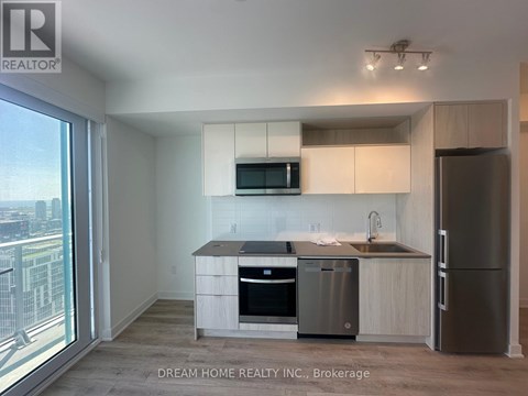 A modern kitchen with stainless steel appliances and a view of the city.