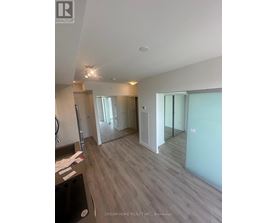 A spacious room with a wooden floor and white walls.