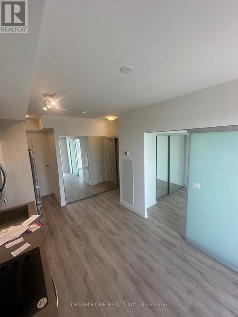 A spacious room with a wooden floor and white walls.