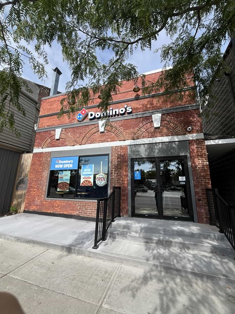 A Donut's shop with a blue signboard and a black gate.