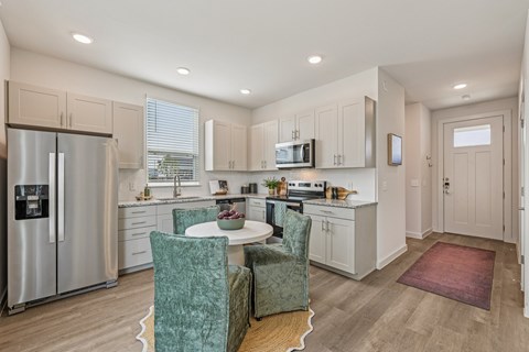 A kitchen with a table and chairs.
